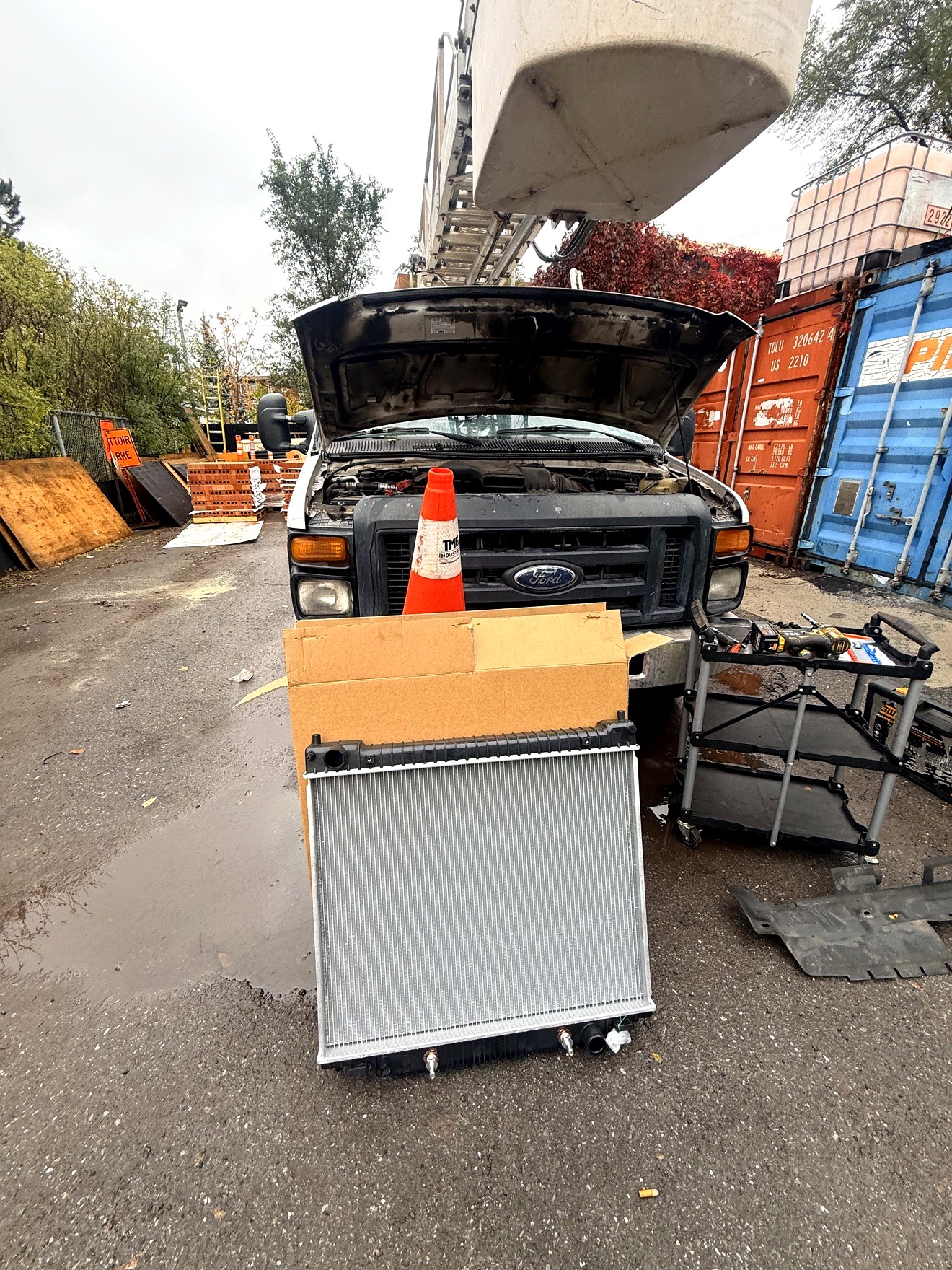 Radiator replacement done on site on a Ford service truck — old radiator out, new radiator installed