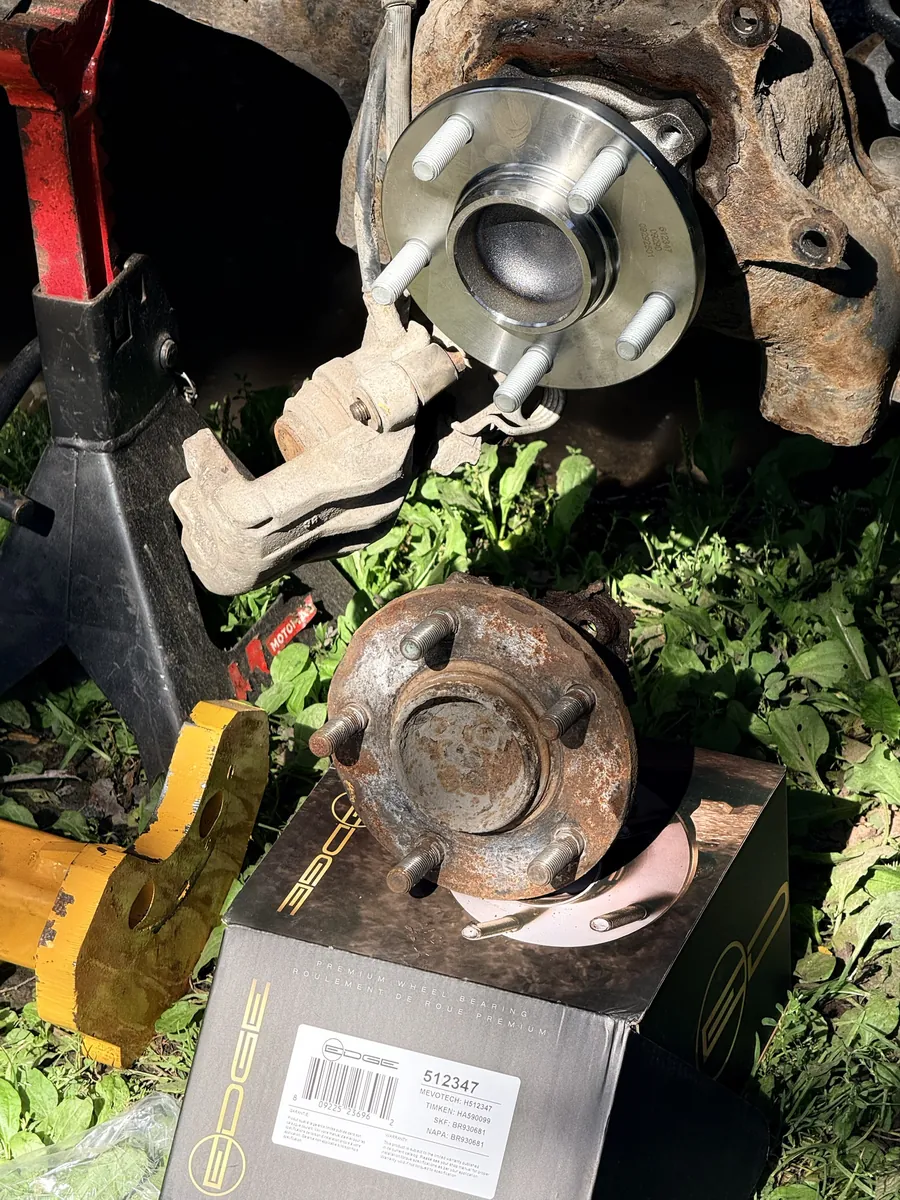 New hub bearing installed above the rusted old hub on its box